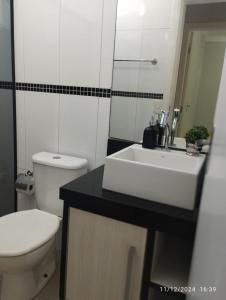 a bathroom with a white sink and a toilet at Mi casa su casa 4 in Londrina +25 photos