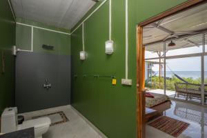 bagno con parete verde e servizi igienici di Abidal Resort a Patnem