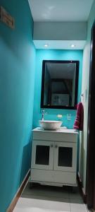 a blue bathroom with a sink and a mirror at Corazón de viajero in Mar del Plata