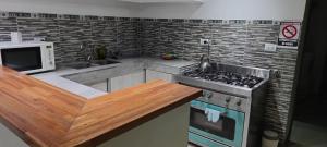 a kitchen with a stove and a microwave at Corazón de viajero in Mar del Plata