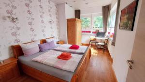 a bedroom with two twin beds and a table at Villa Gast - Salmagundi, für Gruppen bis 16 Gäste in Kamp-Bornhofen