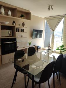 Un comedor con una mesa de cristal y sillas. en Ale Canal Beagle, en Viña del Mar