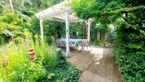 a wooden deck with a table under a white pergola at Villa Gast - Salmagundi, für Gruppen bis 16 Gäste in Kamp-Bornhofen