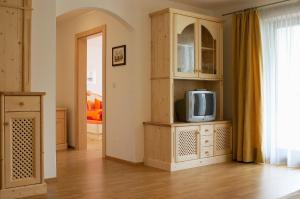 uma sala de estar com uma televisão num armário em Sunnegg em Bressanone