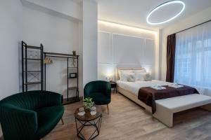 a bedroom with a bed and a couch and a chair at Hama Boutique Stays in Budapest