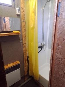 a shower with a yellow shower curtain in a bathroom at Scandinavia bungalow in Kamennaya Gora