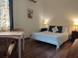 a bedroom with a bed and a table and two lamps at Rumah Putih B&B Sepang - KLIA 1&2 in Sepang