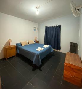 a bedroom with a blue bed and a window at La Mericia in Villa Carlos Paz