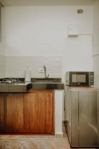 a kitchen with a sink and a microwave at Comfort in Valledupar
