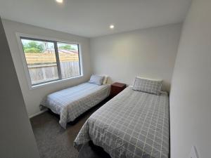 a bedroom with two beds and a window at Town House on Smith in Matamata