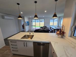 a kitchen with a sink and a living room at Town House on Smith in Matamata