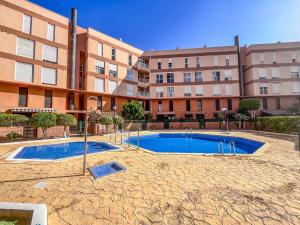 a swimming pool in front of a building at Mariposa in El Médano
