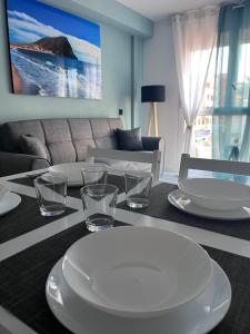 a dining room table with plates and glasses on it at Mariposa in El Médano