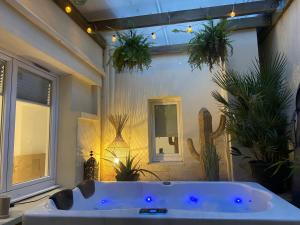 e bagno con vasca e piante in vaso. di CosyRouen Jacuzzi Parking gratuit a Rouen