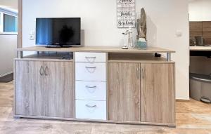 a wooden cabinet with drawers and a television on top at Ferienwohnung Waren Müritz in Waren