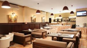 a restaurant with tables and chairs and a bar at Kalasi Hotel in Tbilisi City