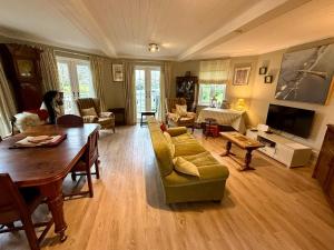 a living room with a couch and a table at Pepperpot Lakeside Lodge on Isis & Windrush Lakes in the Cotswold Lakes in South Cerney