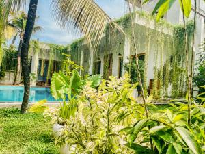 a house with a bunch of plants in the yard at Eton Villa in Dickwella