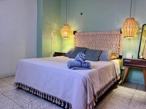 una camera da letto con un letto con un animale di peluche sopra di Hostal Central Oaxaca a Città di Oaxaca