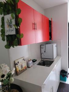 a kitchen with red cabinets and a sink at Serenity Homes with Indoor Jacuzzi in Lipa +7 photos