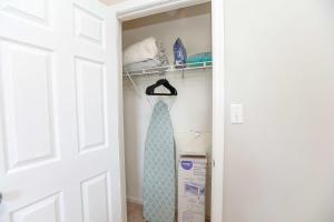 a tie is hanging on a rack in a closet at Sojourn Family Home Sleeps 6 in Norfolk +36 photos