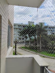 a view of a building through a chain link fence at Apartamento Praia Grande in Ubatuba