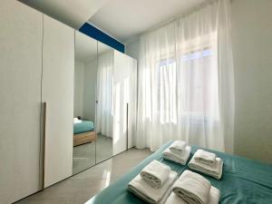 a bedroom with a bed with towels and a mirror at Sergio I Apartment in Rome