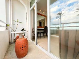 a room with a glass door leading to a room with a table at Beachfront Apartment with Two Queen Beds, Kitchen and Balcony in Boracay