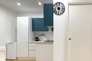マンフレドーニアにあるTORRIONE Apartmentの白いキャビネットと壁掛け時計付きのキッチン +21枚の写真