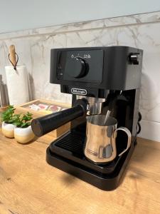 a black coffee maker sitting on a counter at Apart Canada Center in Baia Mare