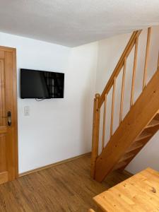 een woonkamer met een trap en een tv aan de muur bij Apartmenthaus Ferdinand in Zell am Ziller +26 foto's