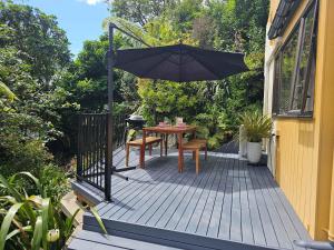 a patio with a table and an umbrella at Beautiful Apartment Surrounded by Native Bush in Picton