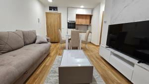 a living room with a couch and a large flat screen tv at El Placer in Zlatibor