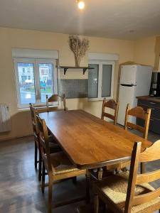 a kitchen with a wooden dining table and chairs at Appartement calme, emplacement stratégique, proche de toutes commodités, de l'autoroute, valenciennes, lille, Belgique, wifi, Netflix, parking Gratuits, lave linge, sèche linge in Raismes