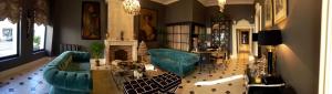 a living room with two blue chairs and a fireplace at Hotel Vendome - BW Signature Collection in Vendôme