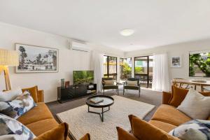 a living room with a couch and a tv at Valley Rd Vibes in Mt Maunganui in Mount Maunganui