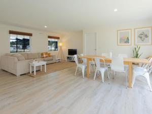 a living room with a wooden table and white chairs at Lyons in Port Fairy