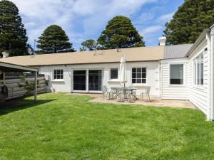 a white house with a table and chairs in the yard at Lyons in Port Fairy