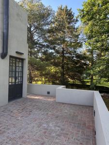 a brick patio with a white wall next to a door at Punta Molinos in La Estancia