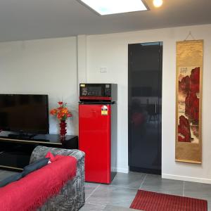 a living room with a red refrigerator and a couch at MOWA Art House Apartment in Huonville +21 photos