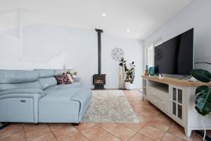 a living room with a couch and a tv at Norah Head Beachside living with Private rooftop in Norah Head
