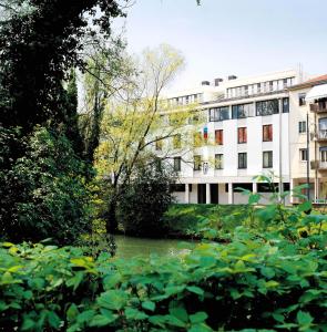 un bâtiment et une rivière devant un bâtiment dans l'établissement Methis Hotel & SPA, à Padoue