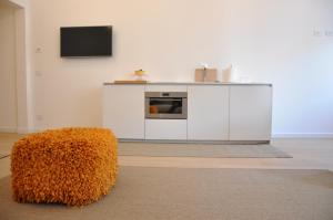 a living room with a couch and a tv on a wall at Appartamento Colonna in Murano