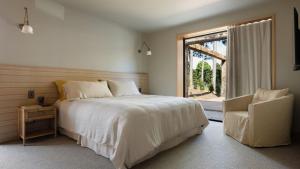 a bedroom with a bed and a window and a chair at Cedar Hill in Newrybar +33 photos