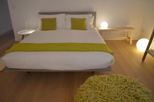 a bedroom with a large bed with a green blanket at Appartamento Colonna in Murano
