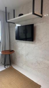 a flat screen tv hanging on a stone wall at VG Sun Cumbuco in Cumbuco