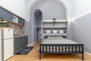 a bedroom with a bed and a kitchen at Elephant and Castle - Exclusive Holiday Home in Catania