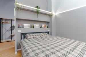 a bedroom with a bed with a plaid blanket at Elephant and Castle - Exclusive Holiday Home in Catania