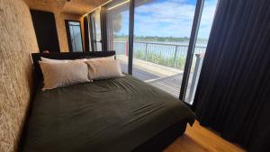 a bedroom with a bed with a view of a balcony at Lake Wellington Luxury Retreat in Wellington East