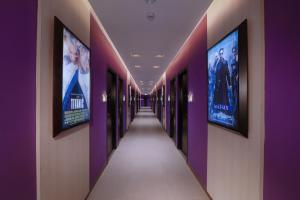 a hallway with purple walls and pictures on the walls at OS Style Hotel Batam Powered by Archipelago in Batu Aji
